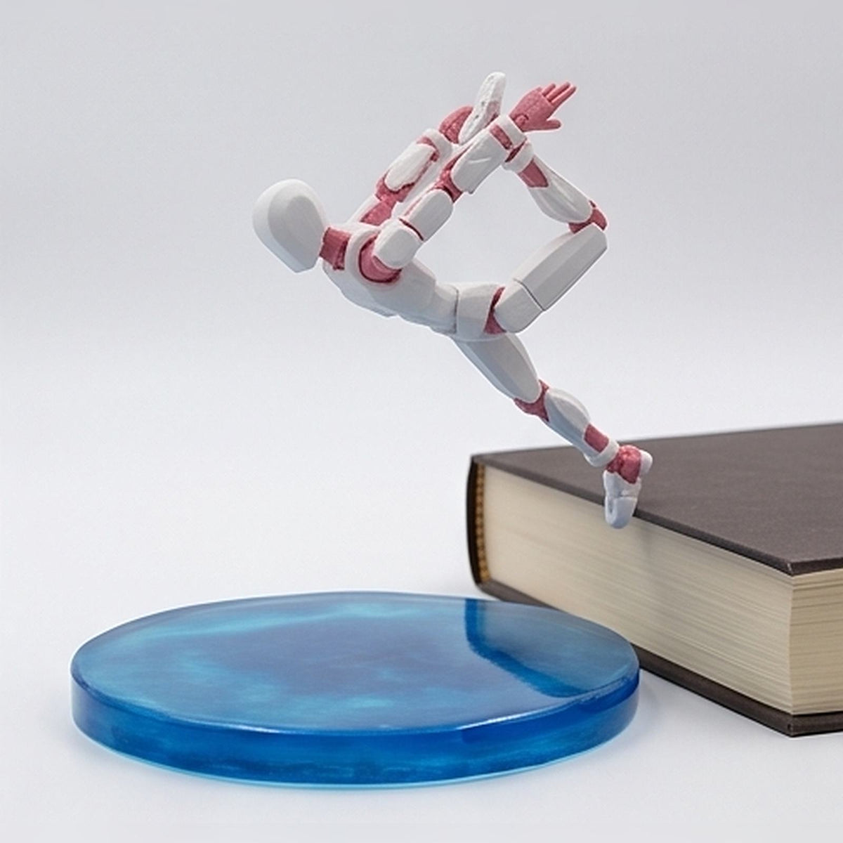 Flexible figurine leaping over a book