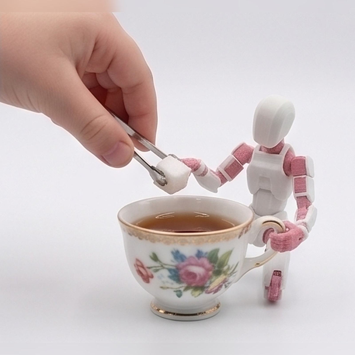 Flexible figurine sat on a teacup being offered a sugar cube