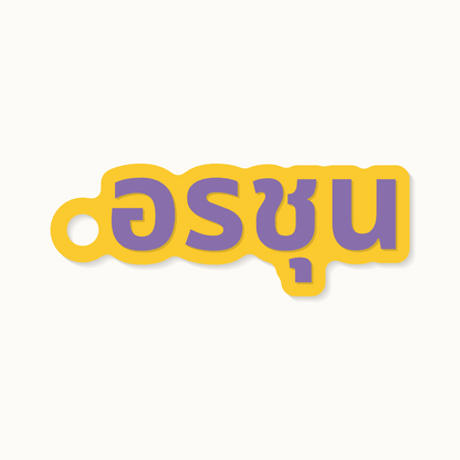 The name Arjun on a keychain in Thai script