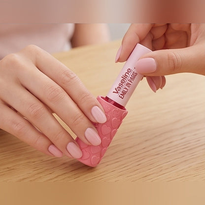 A lip balm being slid into the heart design holder