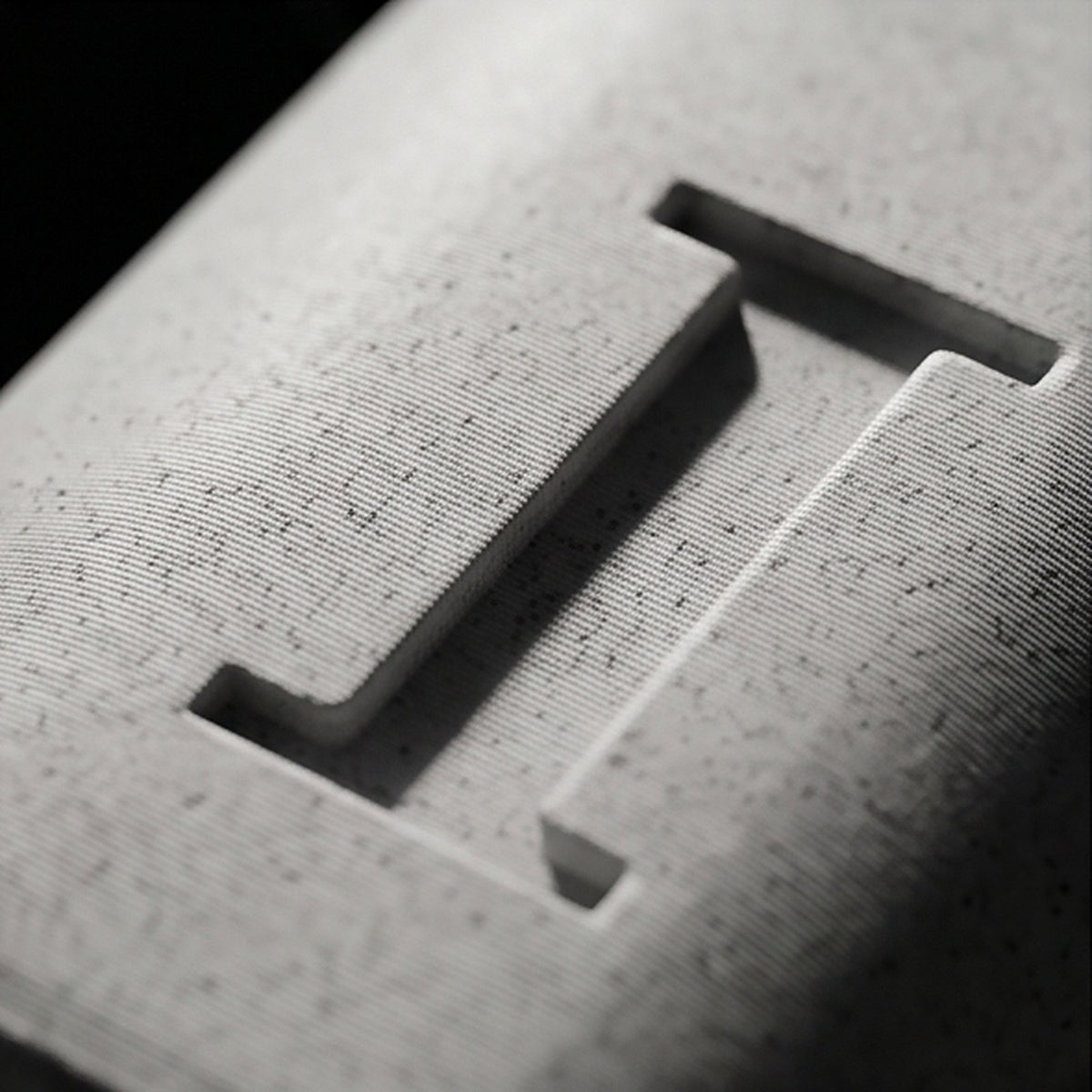Close-up of the recessed monogram letter and the speckled marble texture