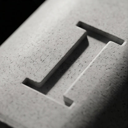 Close-up of the recessed monogram letter and the speckled marble texture