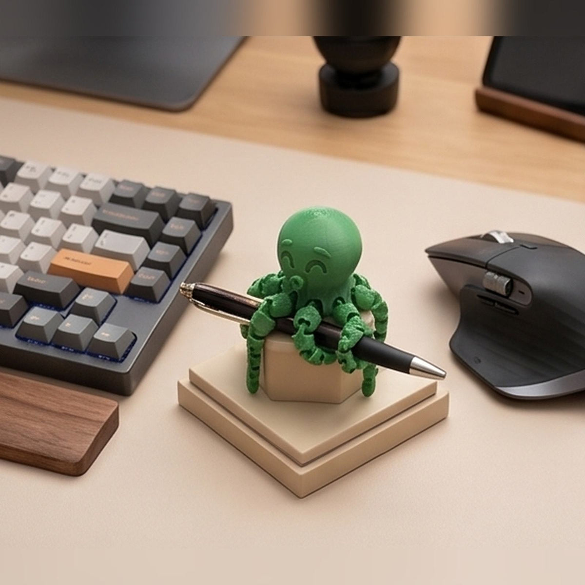 Green articulated octopus holding a pen beside a keyboard
